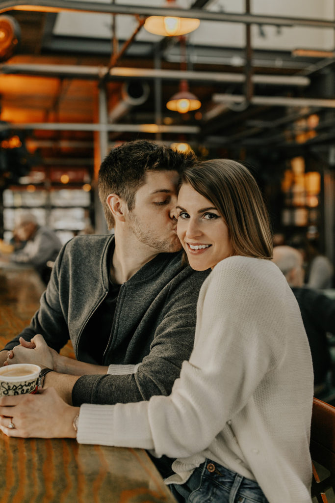 engaged couple drinking coffee in a coffee shop