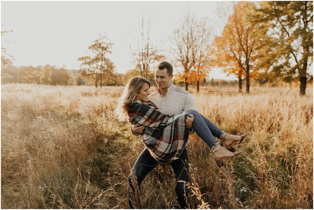fall engagement session, engaged couple in a meadow holding each other