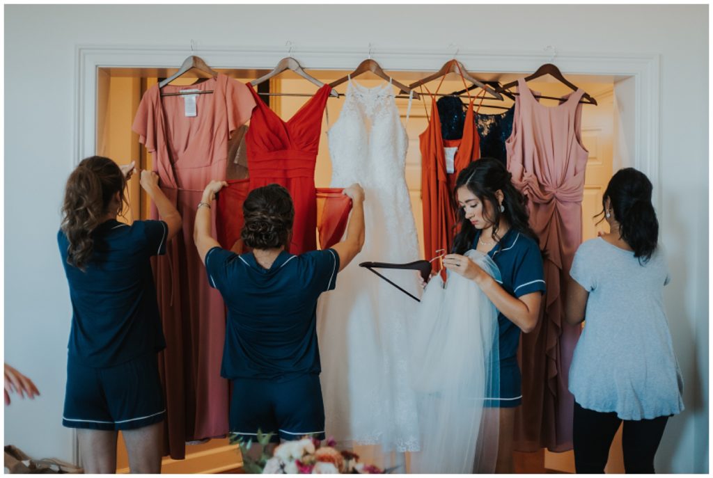 brides getting dressed in their burnt orange and blush dresses