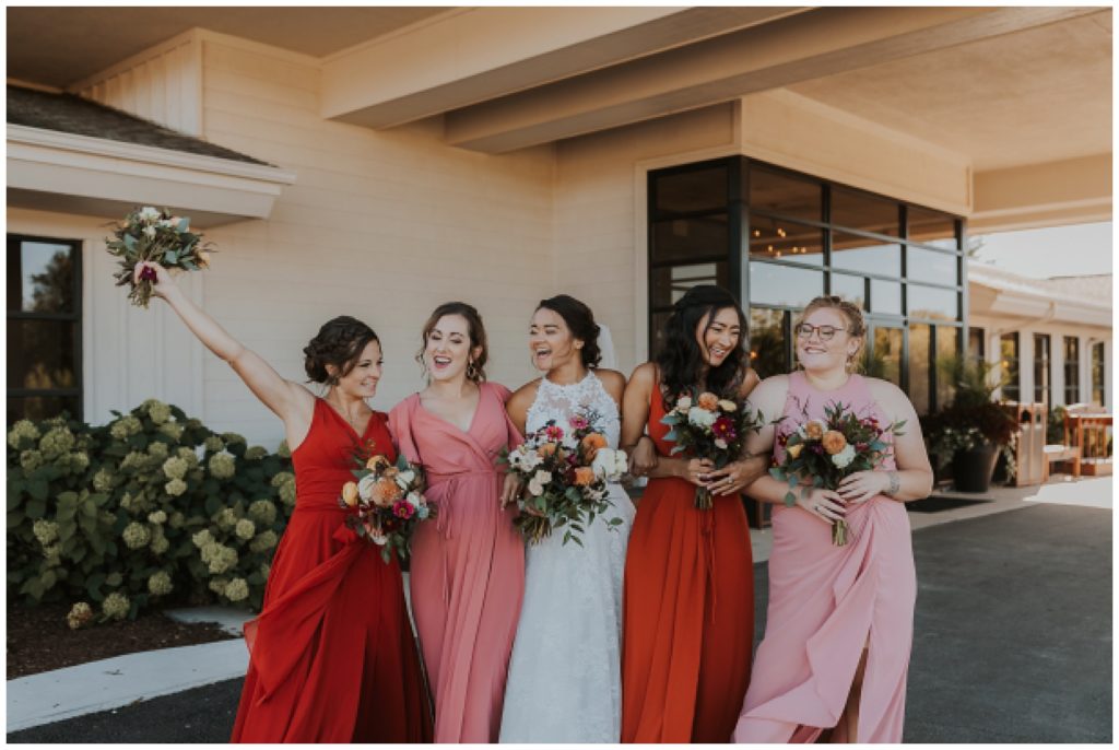 bridal party portraits on wedding day at lac la belle, holding burnt orange and blush bouquets