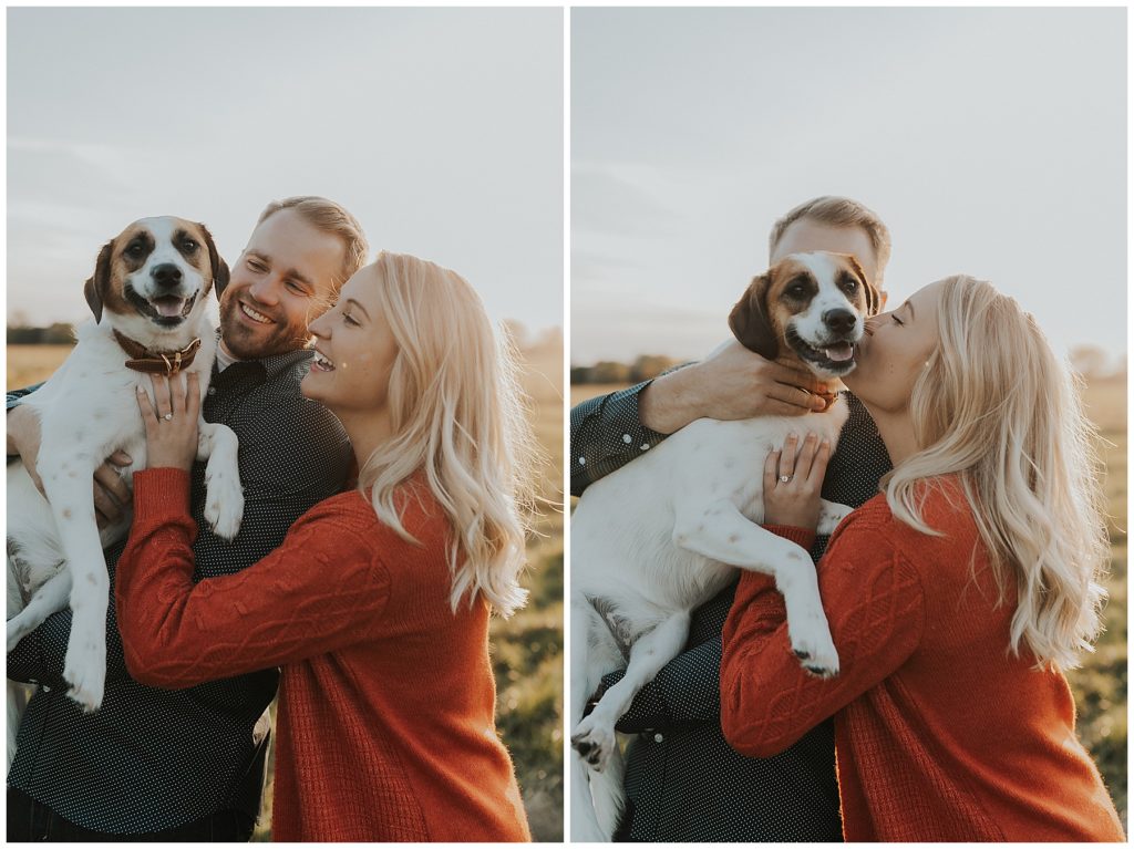 couple taking portraits and playing with their dog in a field during golden hour