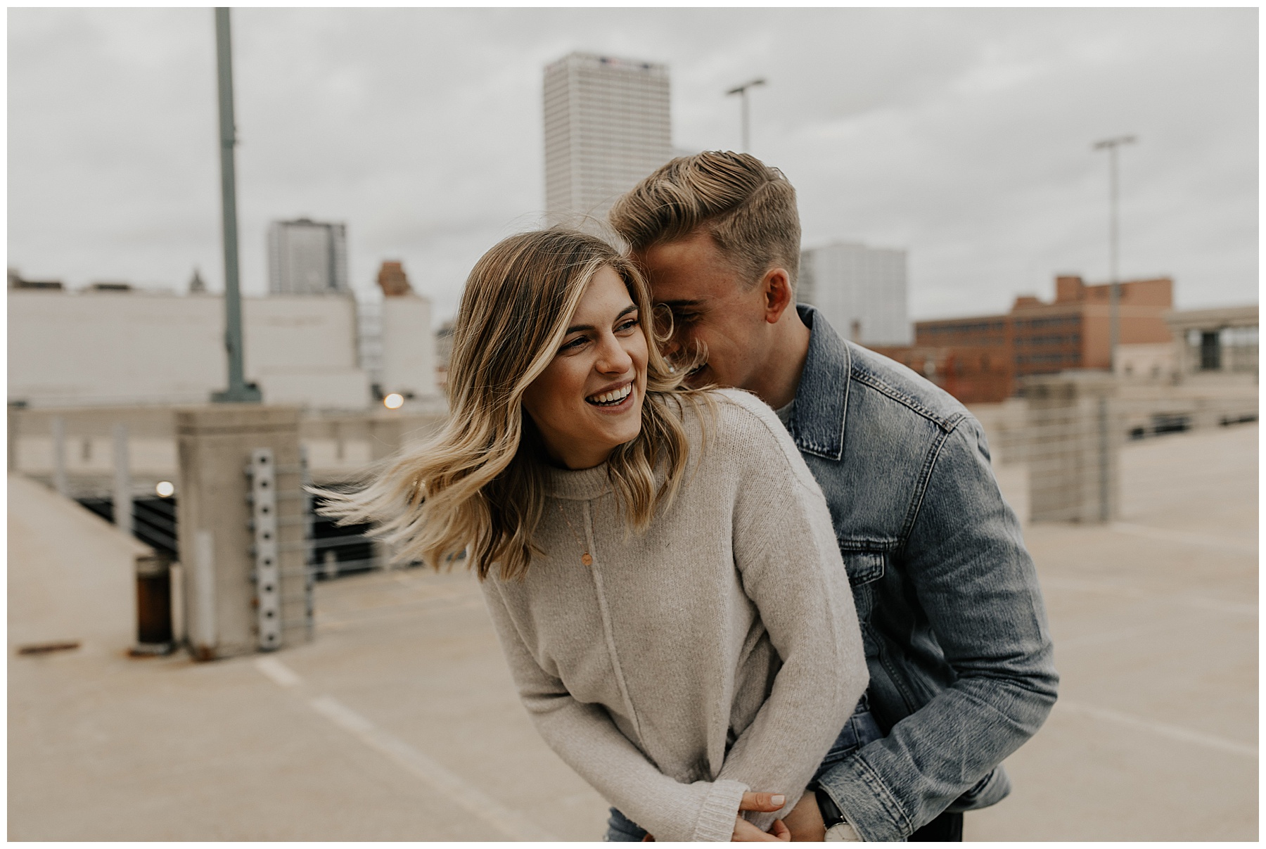 engaged couple taking photos on rooftop during their city engagement session