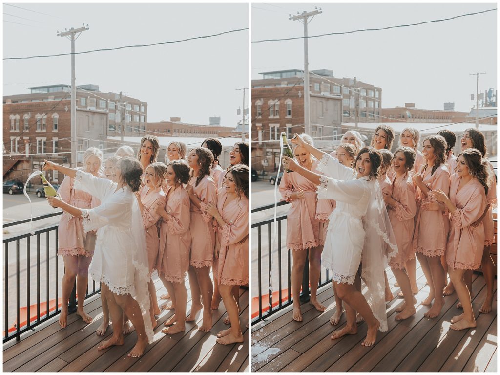 bride and bridesmaids wearing blush silk robes and popping champagne