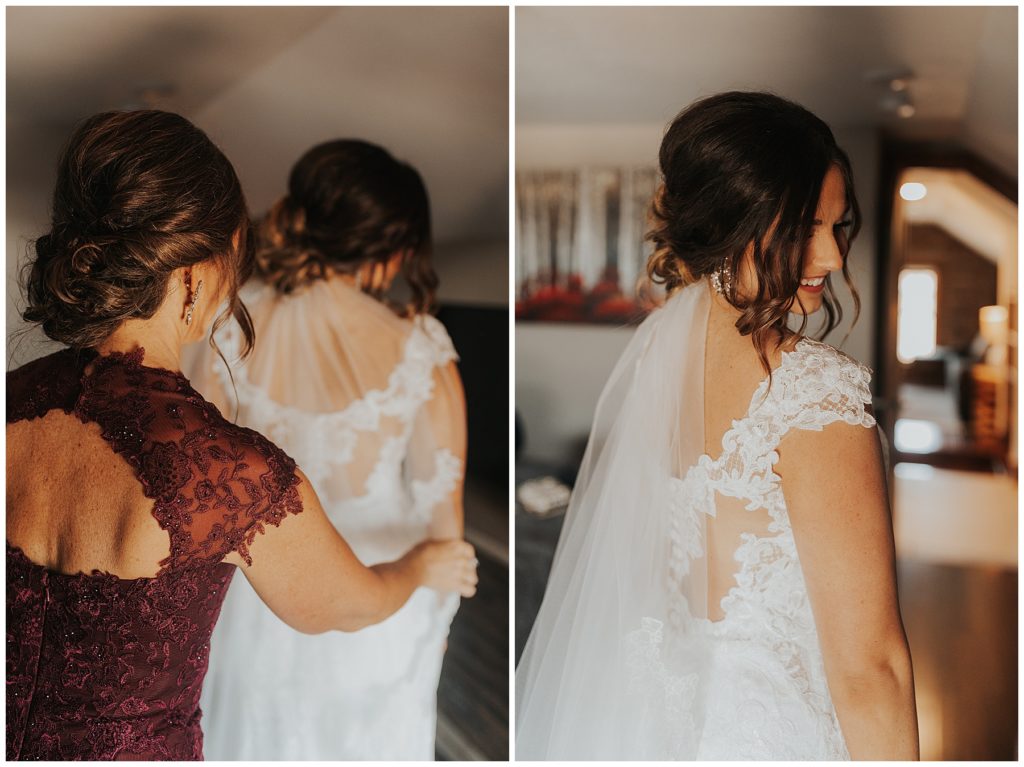 mother of the bride helping bride put on wedding dress