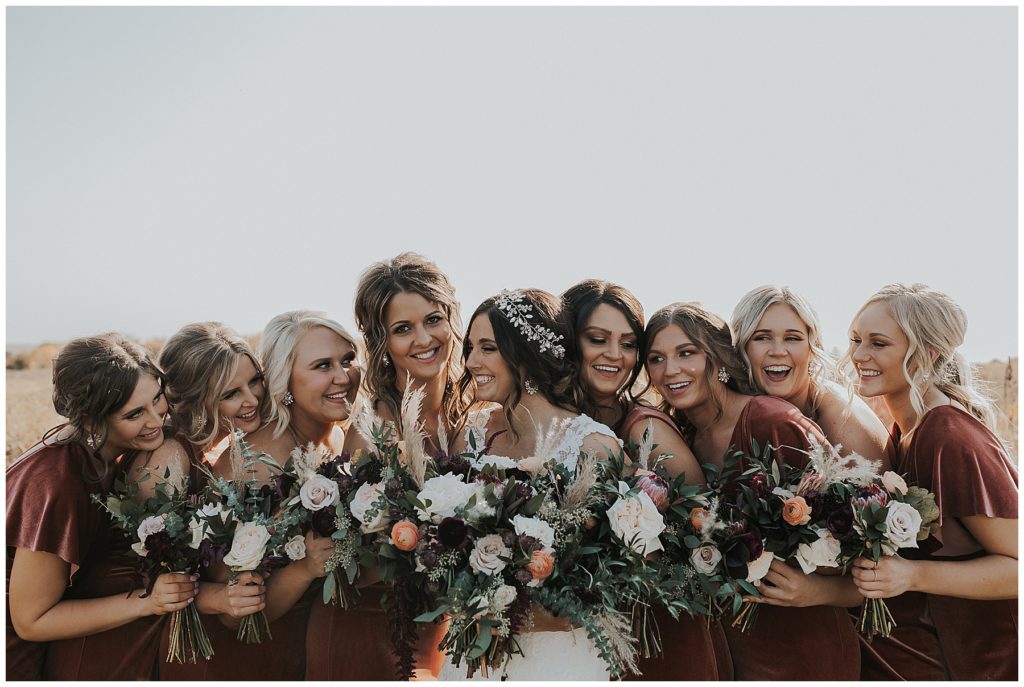 bride posing with her bridesmaids holding bouquets