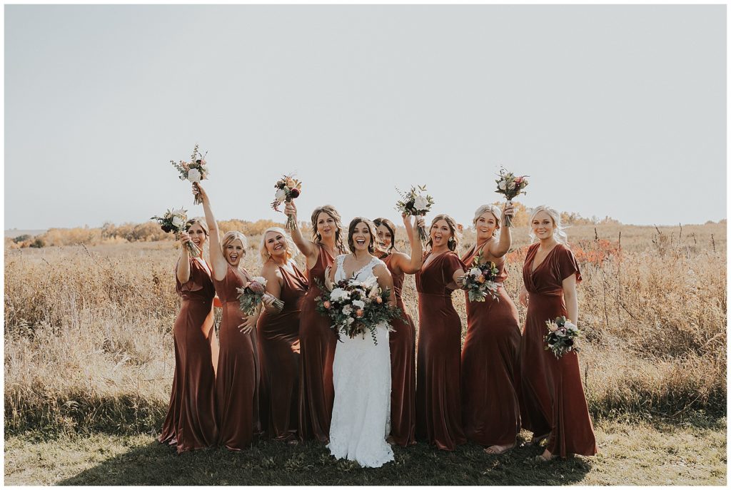 bride posing with her bridesmaids holding bouquets