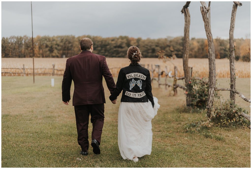 moody portrait of bride and groom on wedding day, bride is wearing an edgy black denim jacket