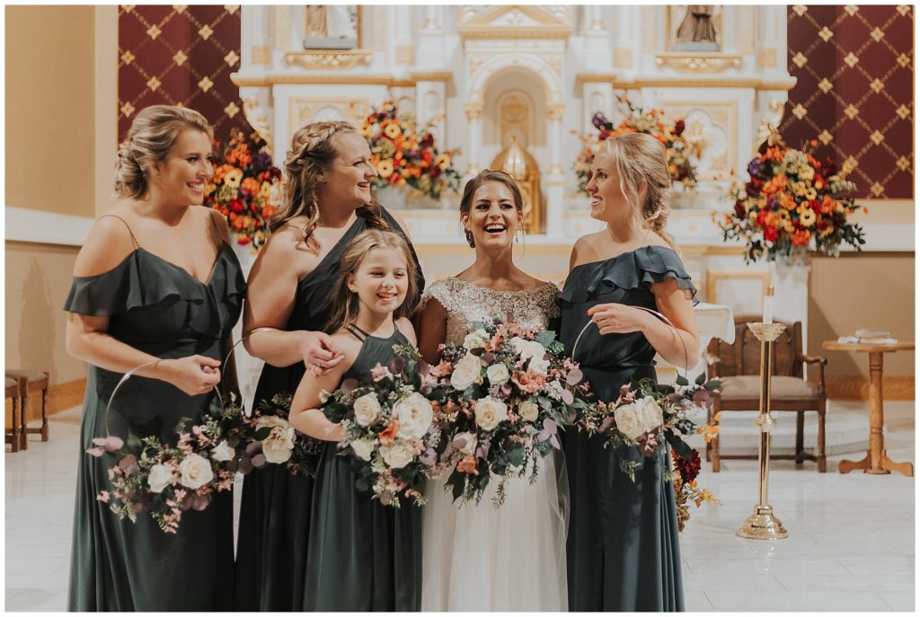 bride and bridesmaids posing with their bouquets in a catholic church